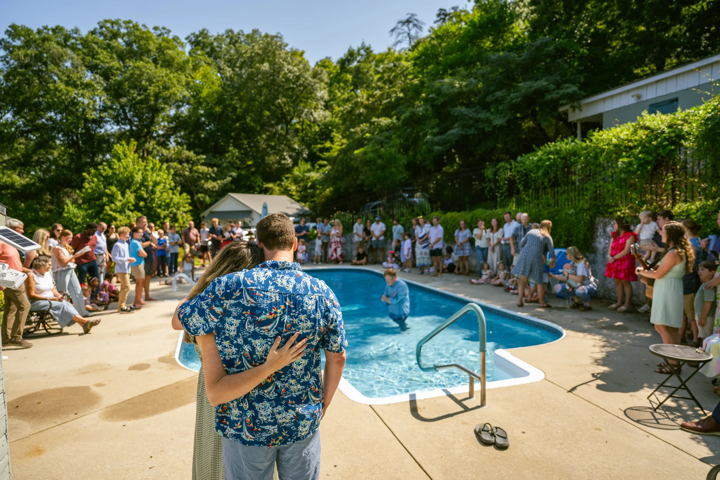 Trinity Fellowship members gathered around a pool during a baptism at Fulton Springs.